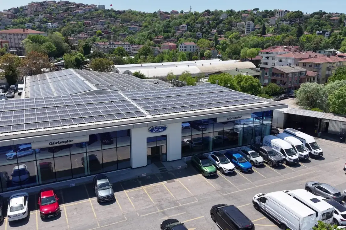 Gürbaşlar Showroom havadan, çatıda güneş panelleri, önde otopark ve cam cephe